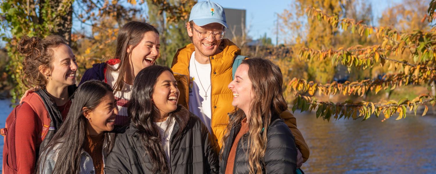 Six SPU students talk and laugh near the canal near campus.